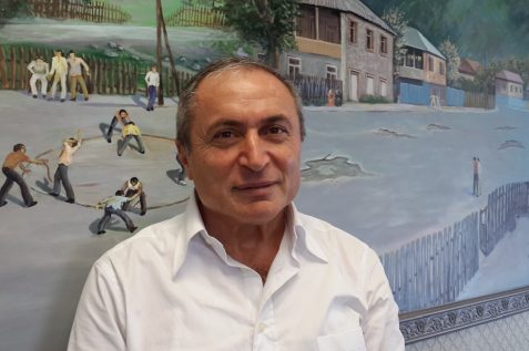 שלום שי // בעלים ומנכל חברת דונה על רקע ציור בית ילדותו בגיאורגיה
